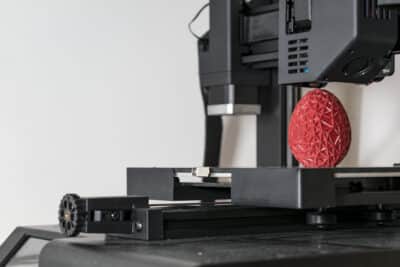 98105490 close up of a 3d printer printing a red polygonal egg La evolución histórica de las impresoras hasta la actualidad